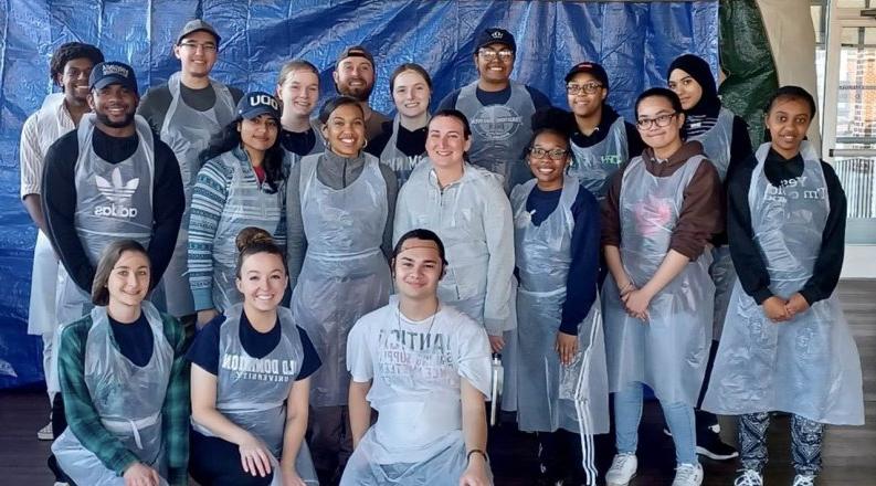 Group of 17 ODU students with plastic aprons; 14 students standing.